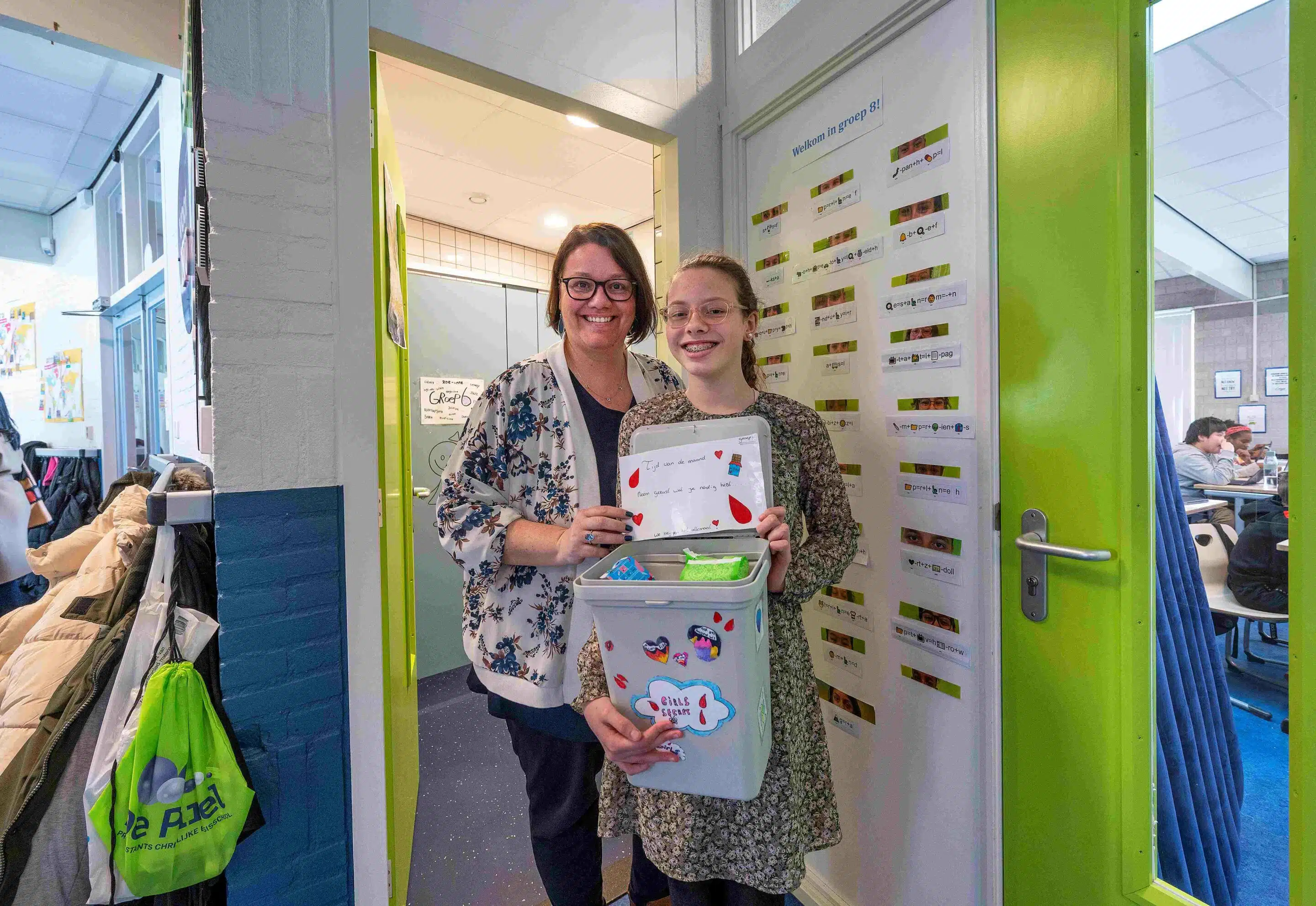 Menstruatieproducten op school Een scholier en docent staan met de gratis menstruatieproducten op een school.